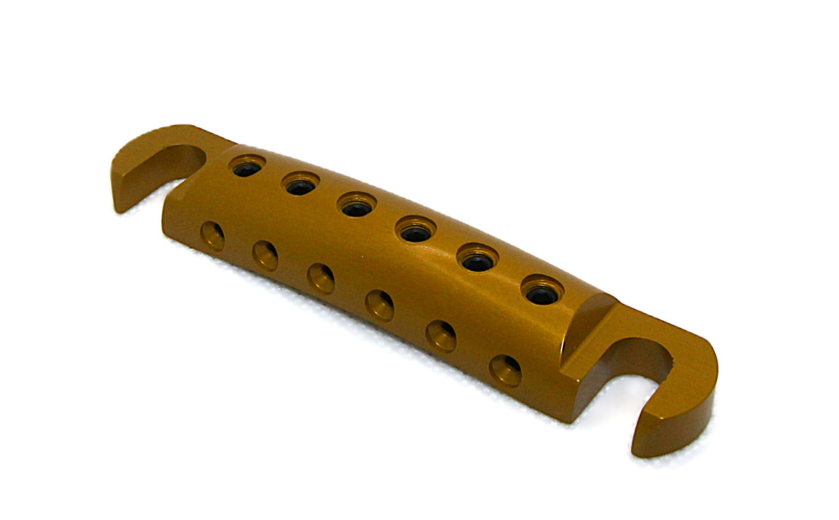 Polished gold anodized Steadfast Stopbar at an angle, showing the string holes and stud slots. Best Quality